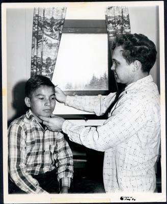 Photograph of Abel Longchamp getting a haircut by teacher Al Shay