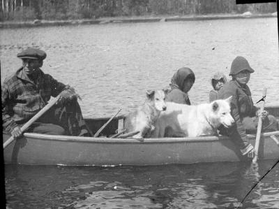Photograph of people and two dogs in a canoe on the Albany River