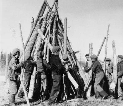 Photograph of boys stacking wood