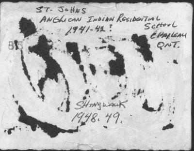 Photograph of a young boy on the steps of the school