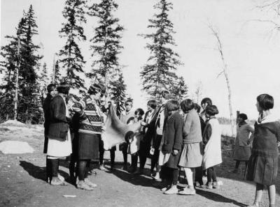 Photograph of students and staff examining an animal pelt