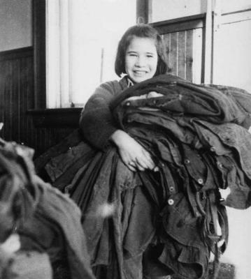 Photograph of Louise (Davies) Redbreast bringing overalls to the sewing room