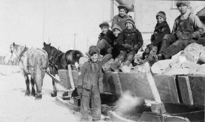 Photograph of students on a sled loaded with wood