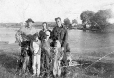 Photograph of Alex Pine and family standing beside the water
