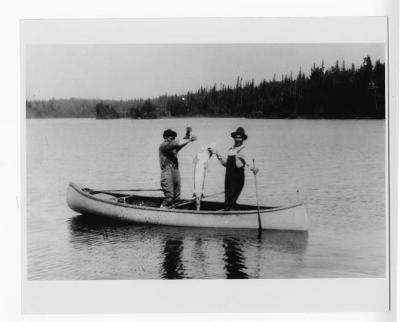 Photograph of two men on a boat with a big fish near Fort Albany