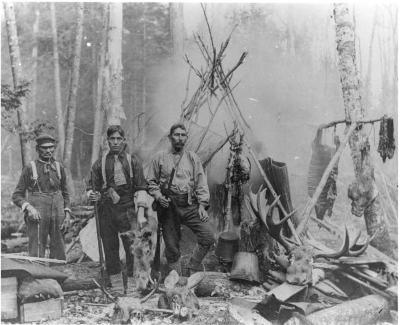 Photograph of three men at a hunt camp
